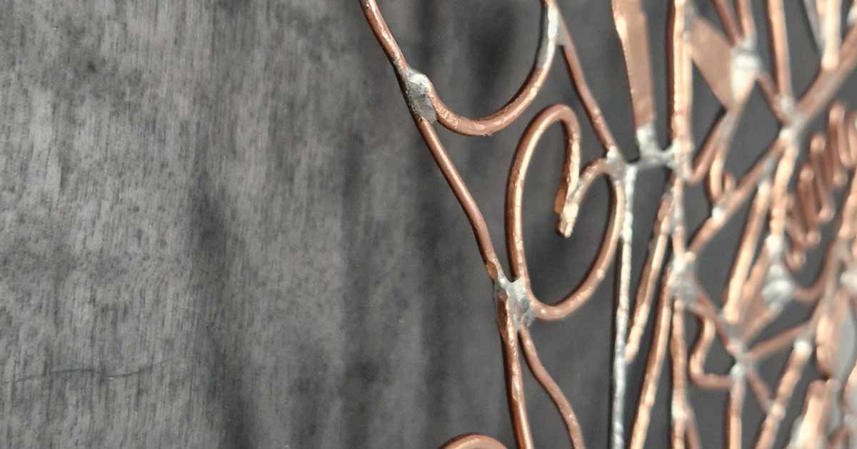 Lucie, sculpture filaire en fil de cuivre d’Amimono, sur panneau noir